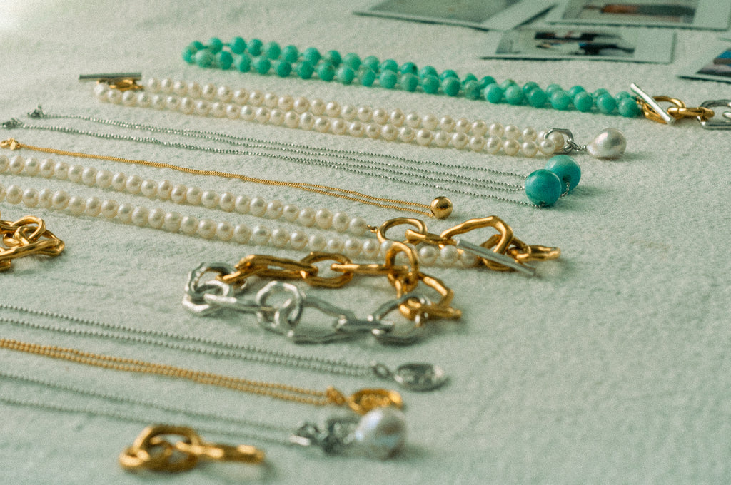 Collection of necklaces and earrings on a textured surface
