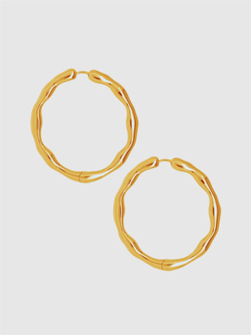 Gold hoop earrings on a light gray background