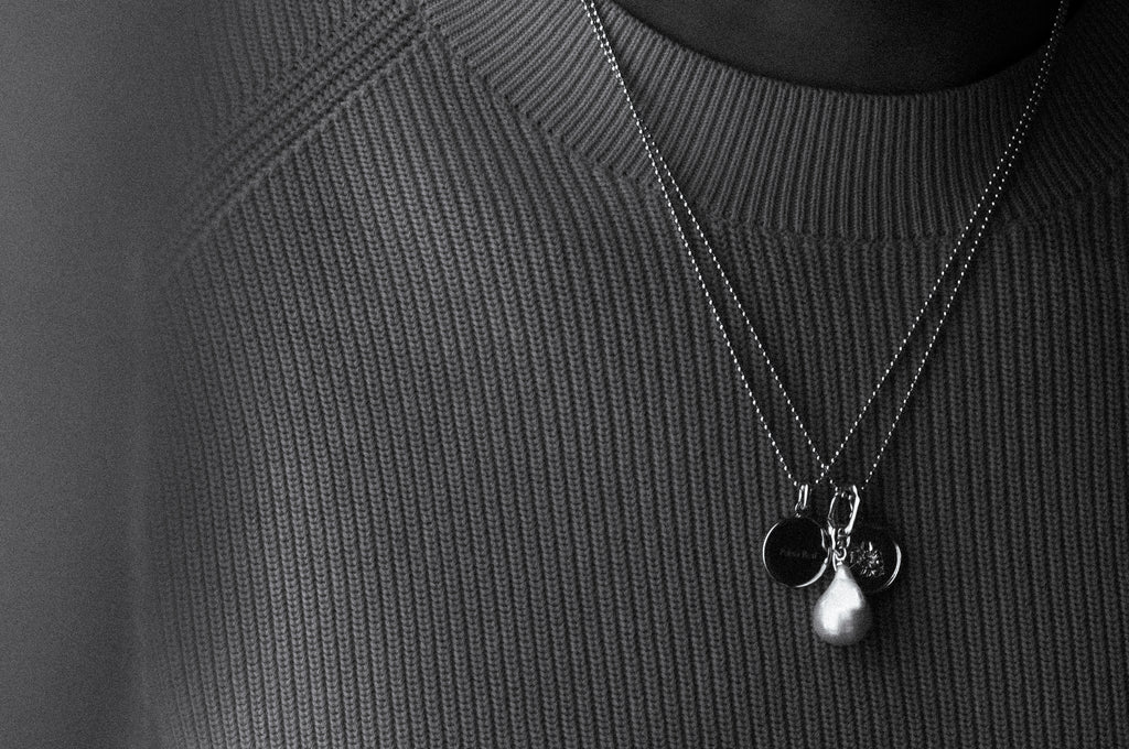 Close-up of a necklace with pendants on a textured black background