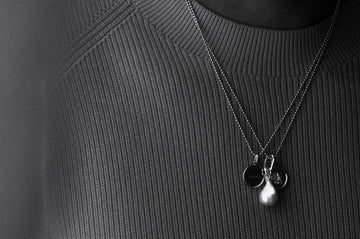 Close-up of a necklace with pendants on a textured black background